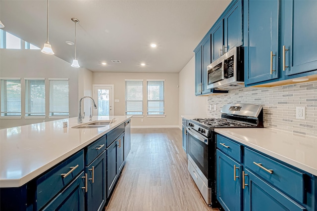 kitchen featuring sink, blue cabinets, pendant lighting, and appliances with stainless steel finishes