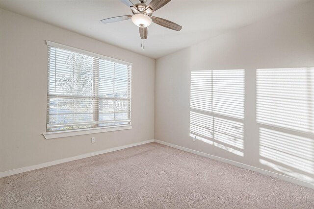 carpeted spare room with ceiling fan