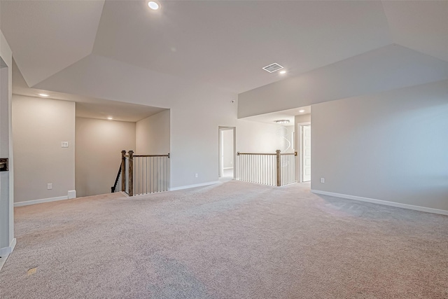 carpeted spare room featuring vaulted ceiling