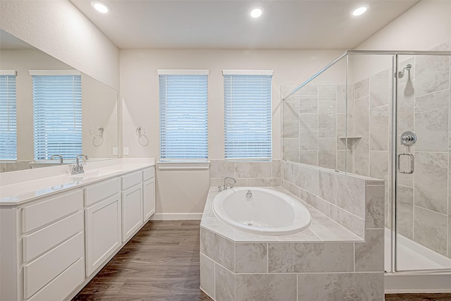 bathroom featuring hardwood / wood-style floors, vanity, and shower with separate bathtub