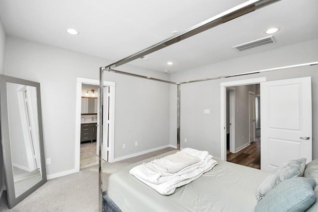 carpeted bedroom featuring ensuite bath