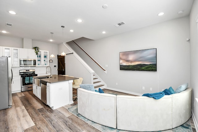 living room featuring sink and light hardwood / wood-style floors