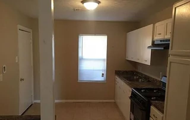 kitchen with white cabinets and black range with electric cooktop