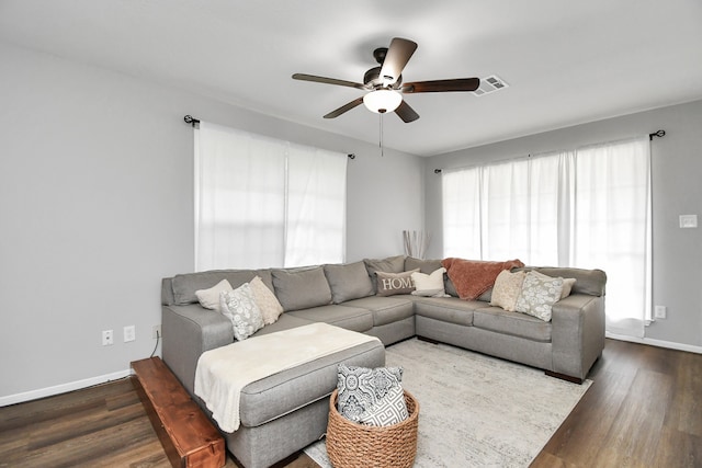 living room featuring ceiling fan and dark hardwood / wood-style flooring