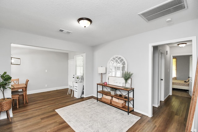 interior space with a textured ceiling, dark hardwood / wood-style flooring, and plenty of natural light