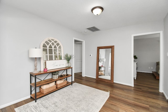 sitting room with dark wood-type flooring