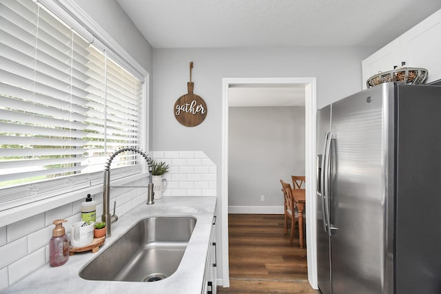 kitchen featuring backsplash, dark hardwood / wood-style flooring, stainless steel fridge with ice dispenser, and sink