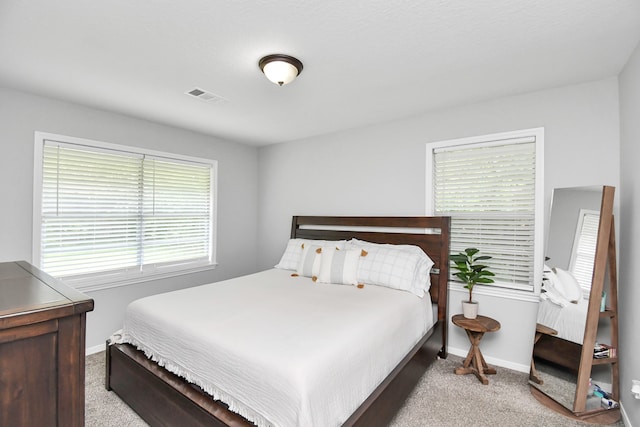 carpeted bedroom featuring multiple windows