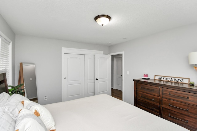 bedroom with a textured ceiling and a closet