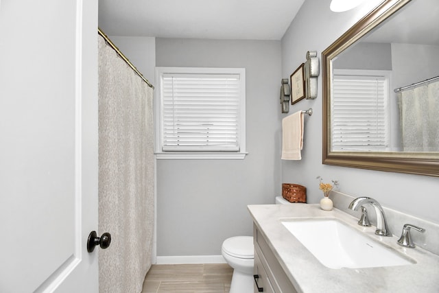 bathroom featuring toilet, vanity, and hardwood / wood-style flooring