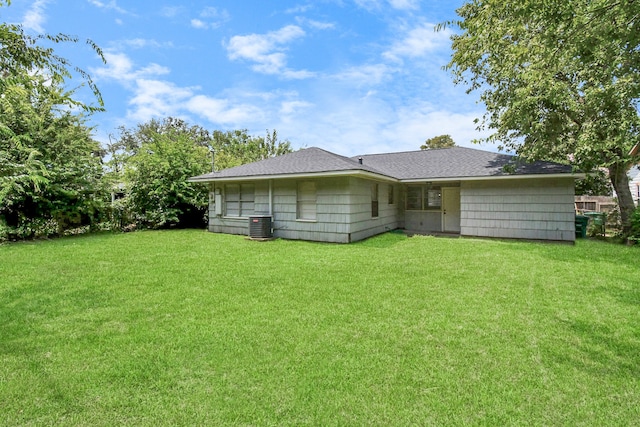 rear view of house featuring a yard and cooling unit