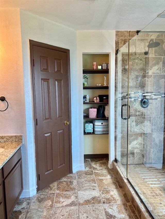 bathroom with vanity and a shower with door