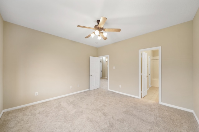 unfurnished bedroom with ceiling fan, light colored carpet, and ensuite bathroom