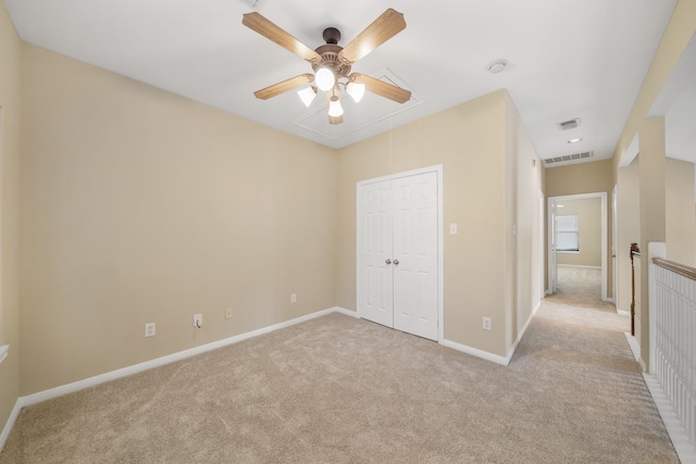 unfurnished bedroom with ceiling fan, a closet, and light colored carpet