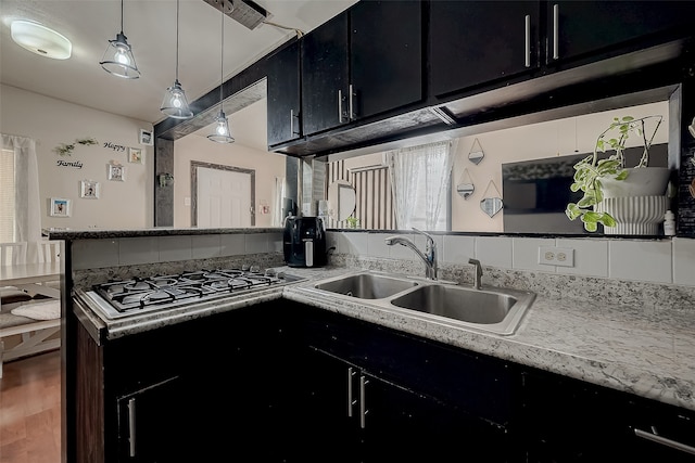 kitchen with pendant lighting, wood-type flooring, sink, and stainless steel gas cooktop