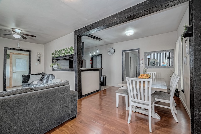 living room featuring hardwood / wood-style floors, ceiling fan, and beam ceiling