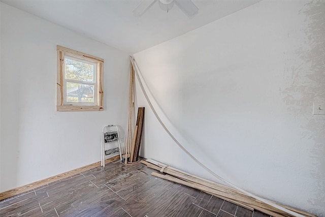 spare room featuring dark hardwood / wood-style flooring, heating unit, and ceiling fan