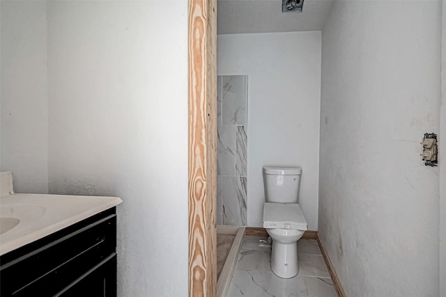 bathroom featuring vanity, toilet, and walk in shower