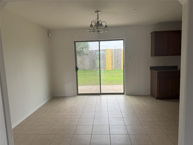 unfurnished dining area featuring light tile patterned floors and a chandelier