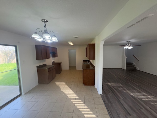 kitchen featuring ceiling fan with notable chandelier and light tile patterned floors