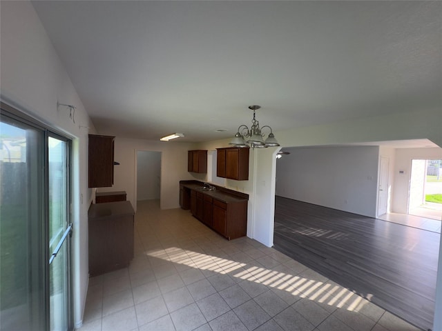 interior space with light tile patterned floors, sink, and a chandelier