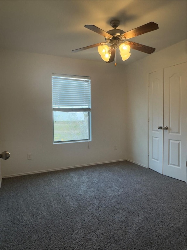 unfurnished bedroom with dark colored carpet and ceiling fan