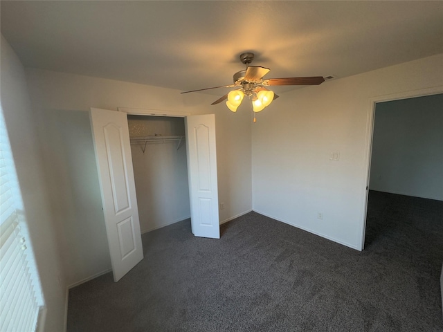 unfurnished bedroom with ceiling fan, a closet, and dark carpet