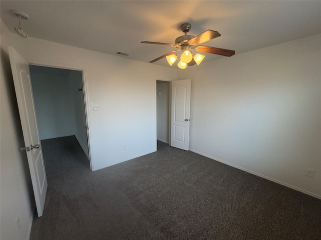 unfurnished bedroom with dark colored carpet and ceiling fan