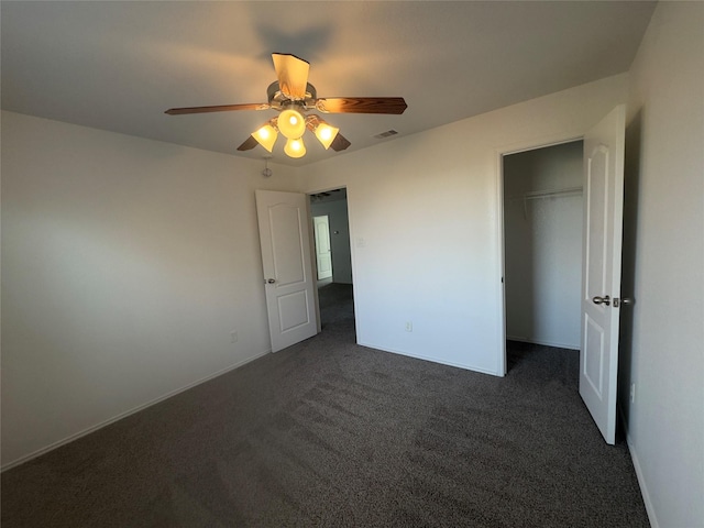 unfurnished bedroom with a closet, dark carpet, and ceiling fan