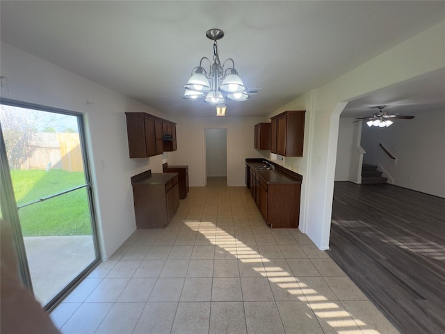 kitchen with ceiling fan with notable chandelier, light tile patterned flooring, and sink