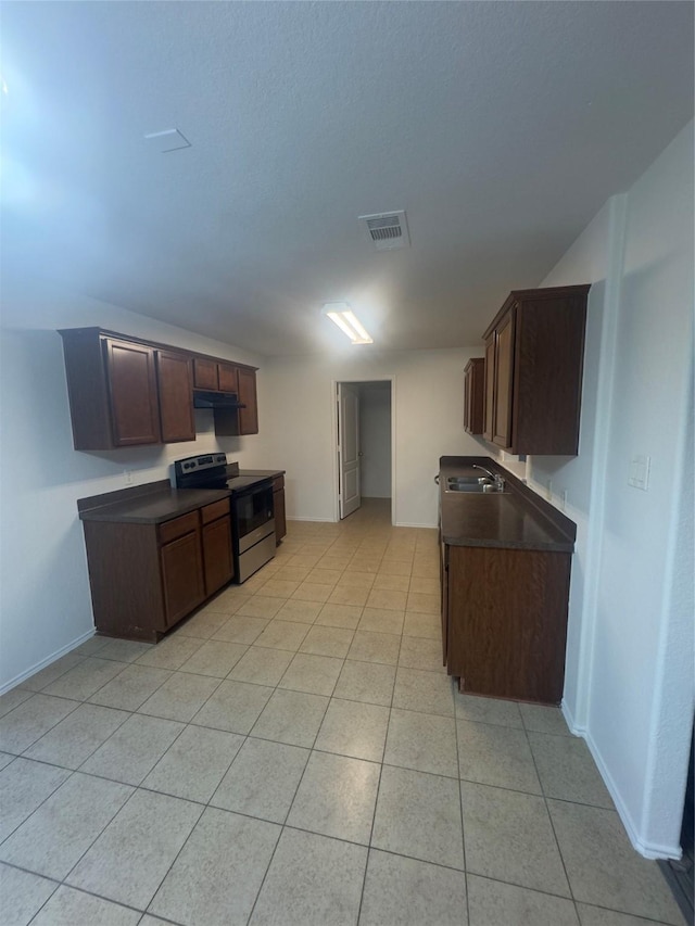 kitchen featuring sink, light tile patterned floors, stainless steel range with electric cooktop, and dark brown cabinetry