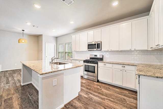 kitchen featuring white cabinets, dark hardwood / wood-style flooring, stainless steel appliances, and hanging light fixtures