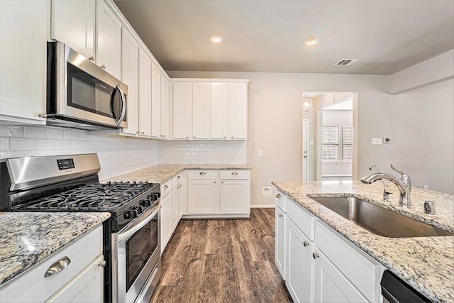 kitchen featuring white cabinets, sink, dark hardwood / wood-style floors, light stone countertops, and stainless steel appliances