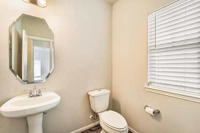 bathroom featuring plenty of natural light and toilet