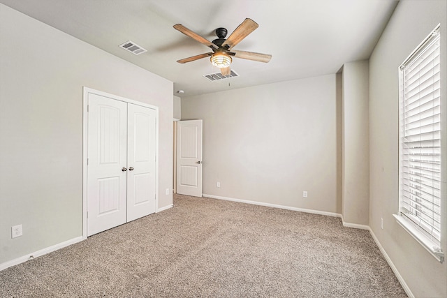 unfurnished bedroom with ceiling fan, a closet, and carpet