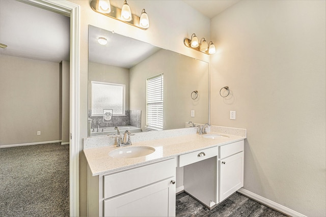 bathroom with wood-type flooring, vanity, and a tub