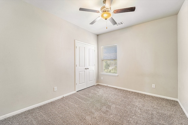 carpeted spare room with ceiling fan