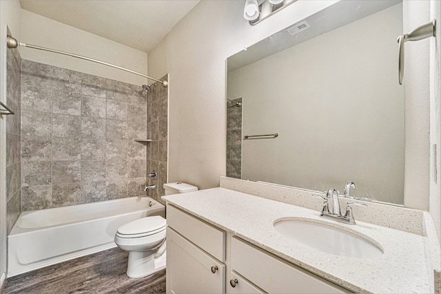 full bathroom with vanity, toilet, wood-type flooring, and tiled shower / bath