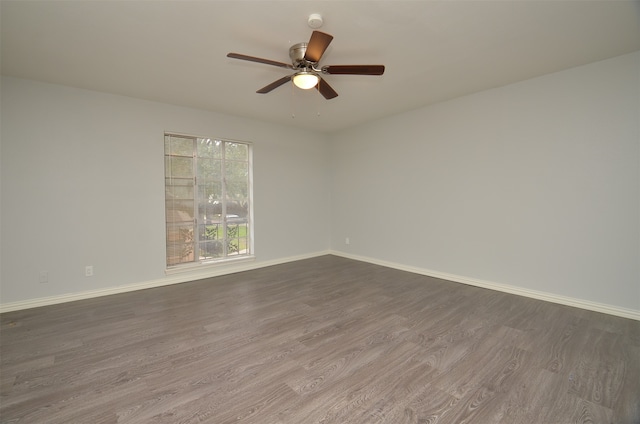 unfurnished room with ceiling fan and dark wood-type flooring