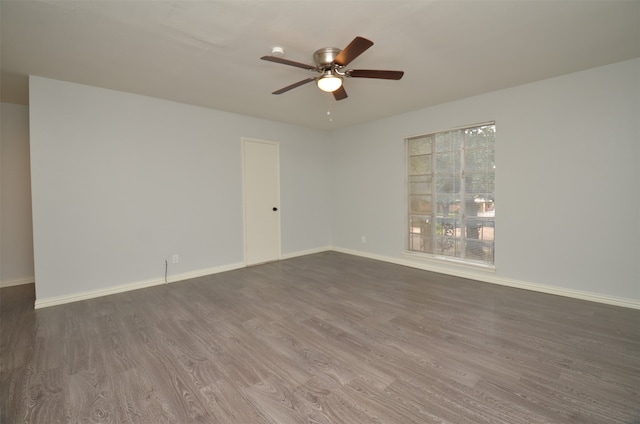 empty room featuring ceiling fan and dark hardwood / wood-style flooring