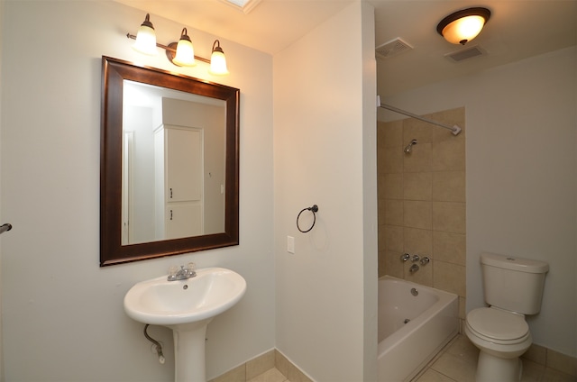 bathroom with tile patterned floors, tiled shower / bath, and toilet