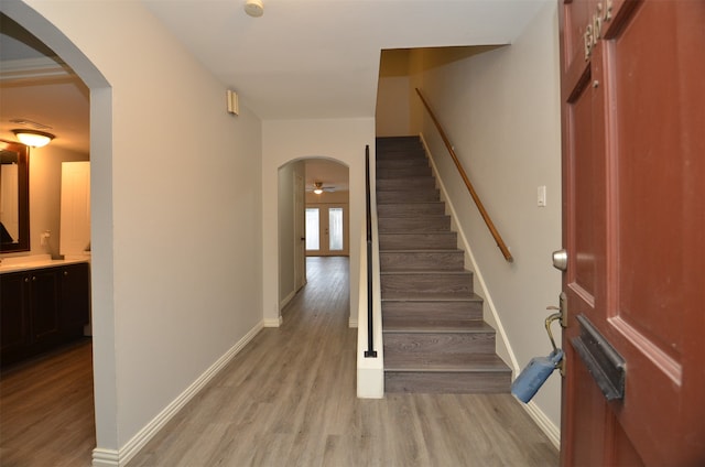 foyer entrance with ceiling fan and light wood-type flooring