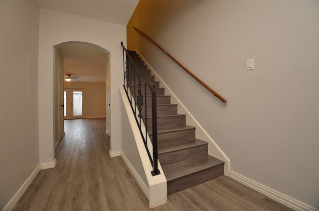 stairway featuring ceiling fan and wood-type flooring