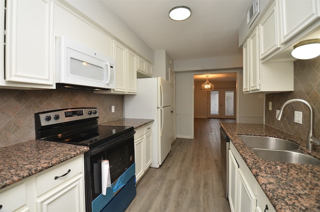 kitchen featuring light hardwood / wood-style floors, white appliances, sink, and dark stone counters