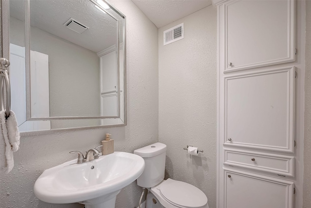 bathroom featuring sink, a textured ceiling, and toilet