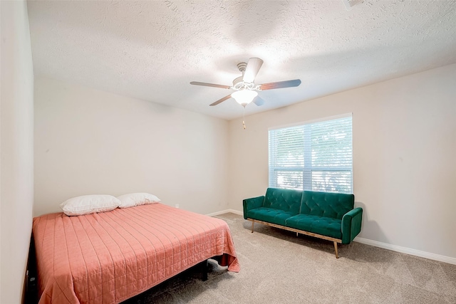 carpeted bedroom featuring ceiling fan and a textured ceiling