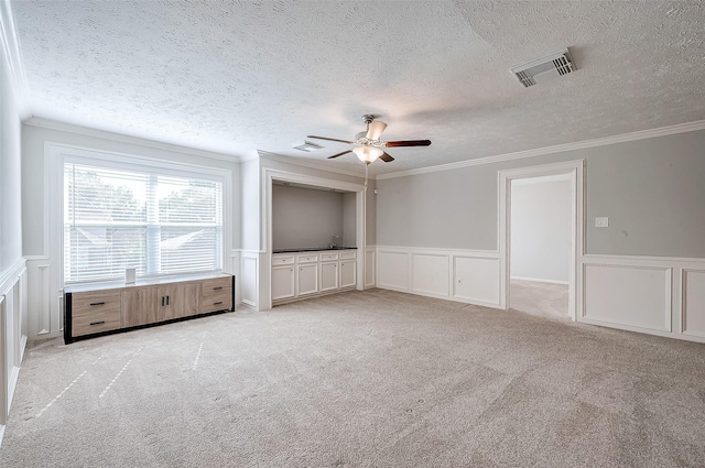 unfurnished living room with crown molding, ceiling fan, light carpet, and a textured ceiling