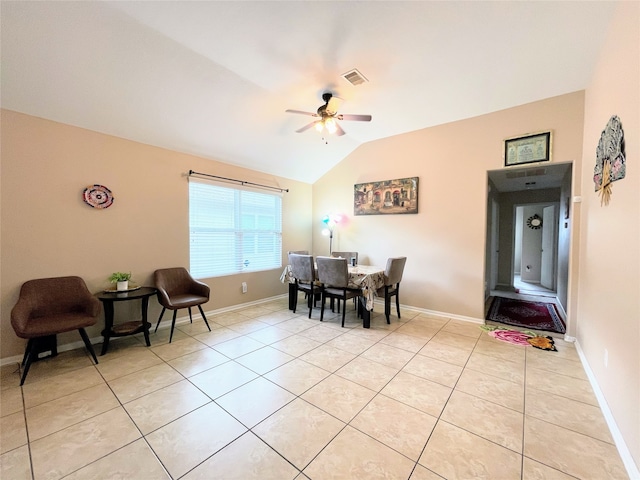 tiled dining space with ceiling fan and vaulted ceiling