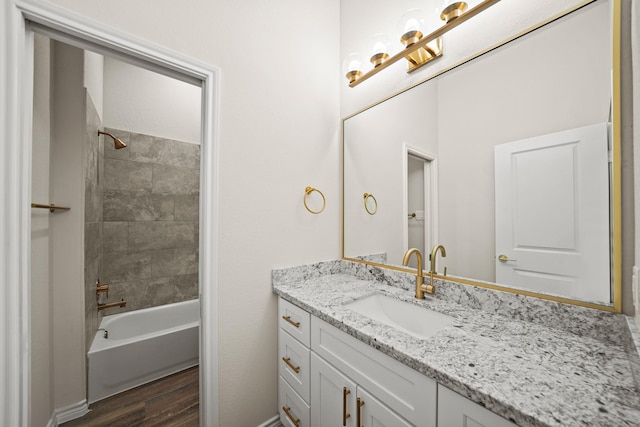 bathroom featuring vanity, tiled shower / bath combo, and hardwood / wood-style flooring