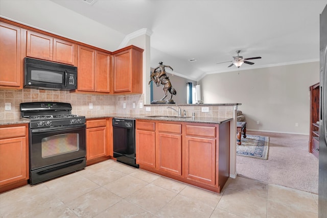 kitchen featuring light carpet, kitchen peninsula, light stone counters, sink, and black appliances